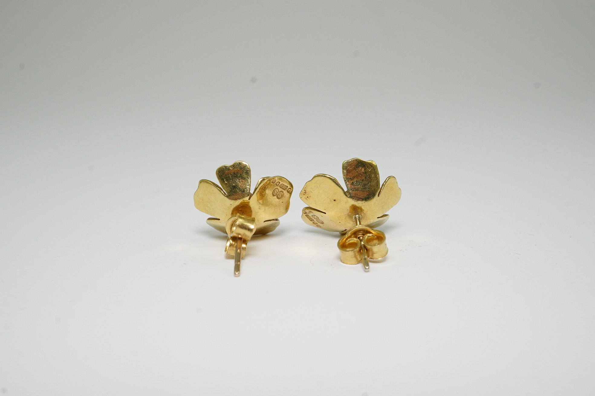 A pair of 1970's 18ct gold and single stone emerald set flower head earrings